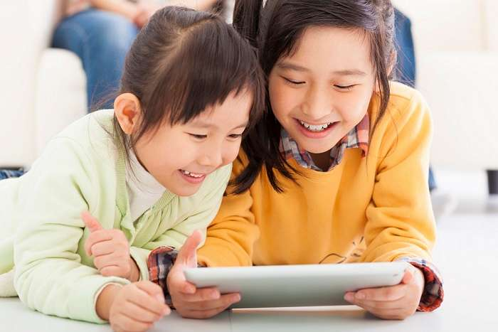 happy little girls using tablet computer
