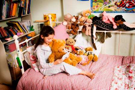 Girl holding a personal data assistant on the bed